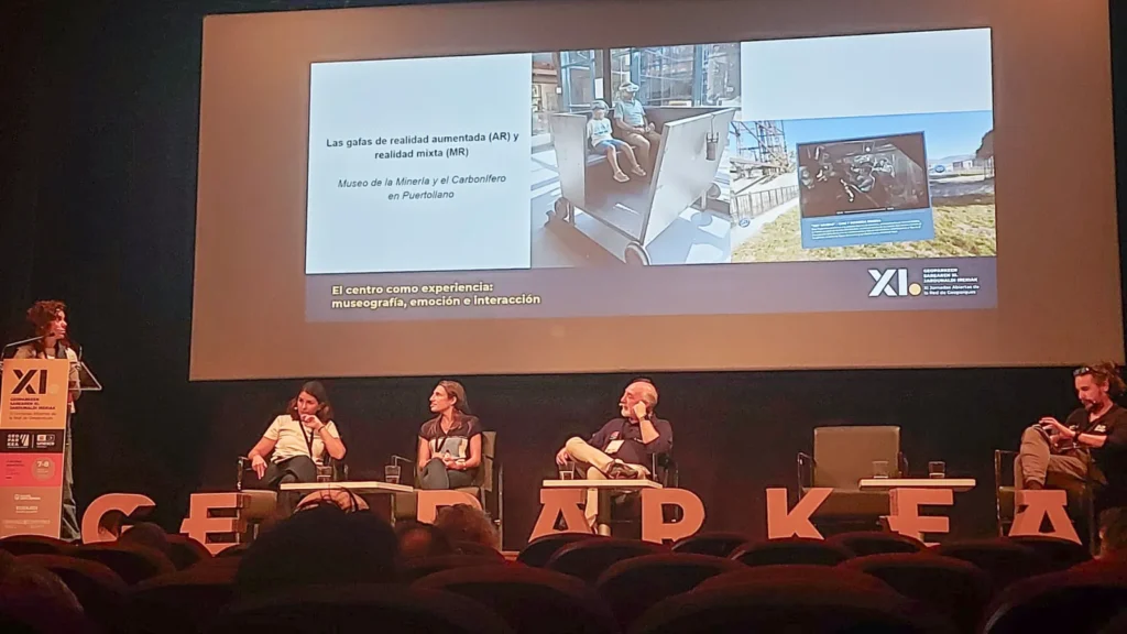 Mesa redonda de las XI Jornadas de la Red Española de Geoparques con una diapositiva sobre las gafas de realidad aumentada y mixta del Museo de la Minería de Puertollano